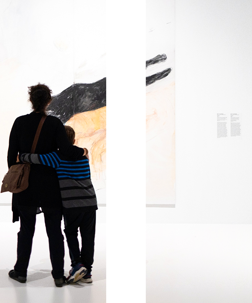 Image en forme du symbole pause d’une mère et de son enfant regardant une œuvre.